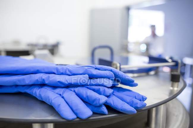 Protective gloves on tank of cryostorage facility. — Stock Photo