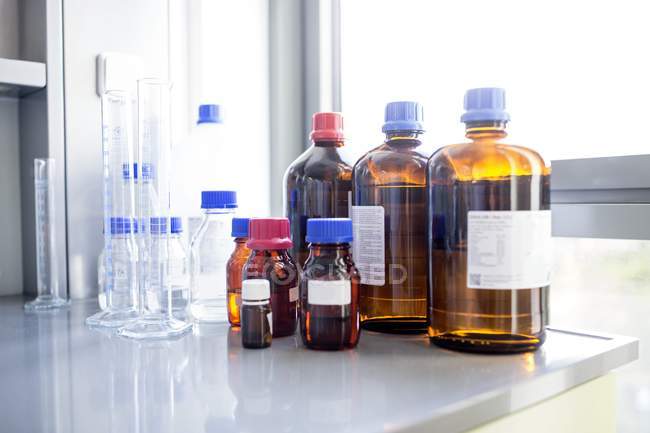 Laboratory solutions and glassware on table. — Stock Photo