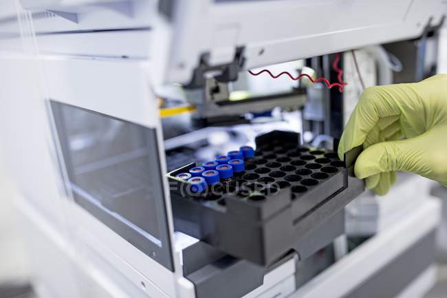 Gros plan d'un scientifique plaçant des échantillons à la main dans un concentrateur . — Photo de stock