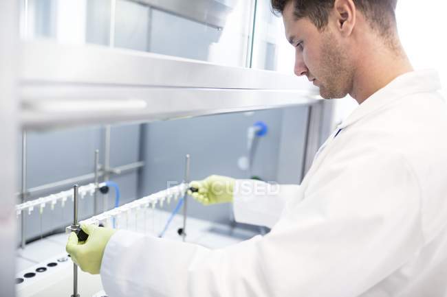 Technician placing solid phase extraction columns on stand. — Stock Photo