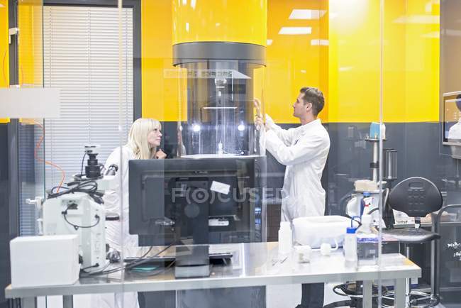 Techniciens programmant la machine d'électrofilage dans le laboratoire de nanofibre . — Photo de stock