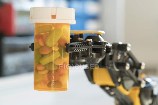 Роботизована рука тримає пляшку медичних таблеток . — стокове фото