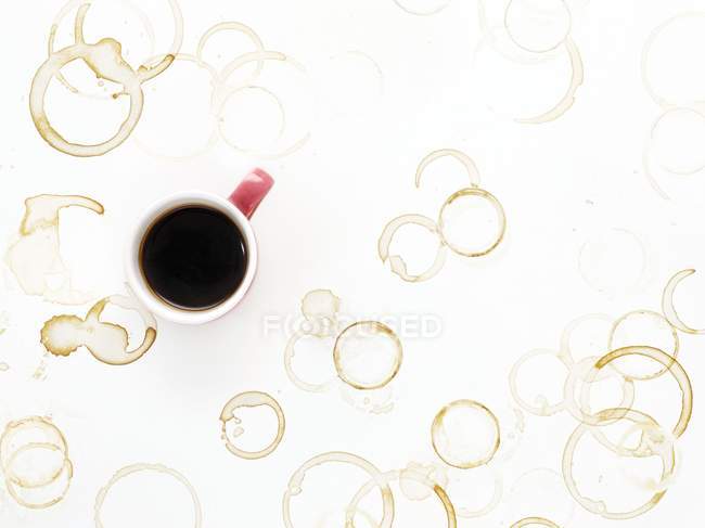 Kaffeetasse und Flecken auf dem Tisch, Blick aus dem hohen Winkel. — Stockfoto