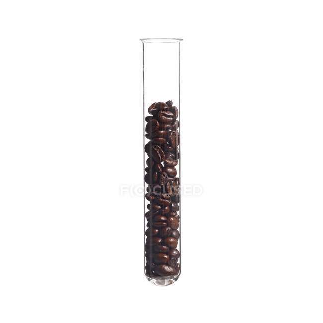 Kaffeebohnen im Reagenzglas auf weißem Hintergrund, Studioaufnahme. — Stockfoto