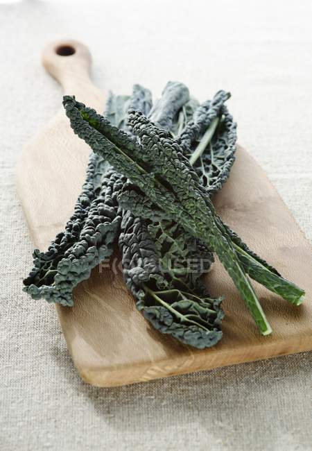 Kale vegetable on wooden chopping board. — Stock Photo