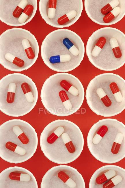 Папір медицини горщики з червоними і білими наркотиків капсули і Разова доза синьо-білу капсули. — стокове фото