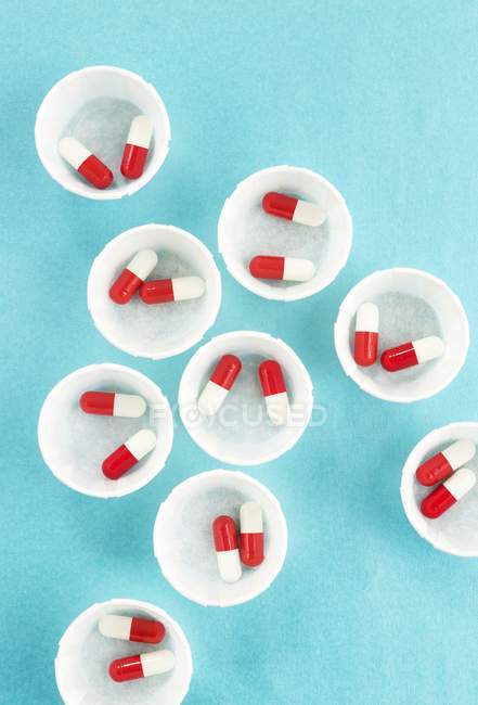 Вид зверху папір медицини горщиків з червоними і білими наркотиків капсули. — стокове фото