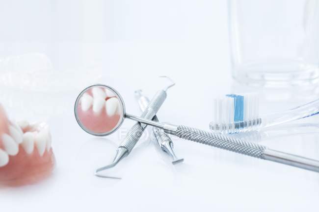 Equipo y herramientas de clínica dental contra fondo blanco . - foto de stock
