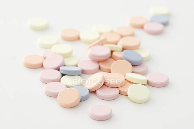 Bunte Antazida-Tabletten vor weißem Hintergrund. — Stockfoto