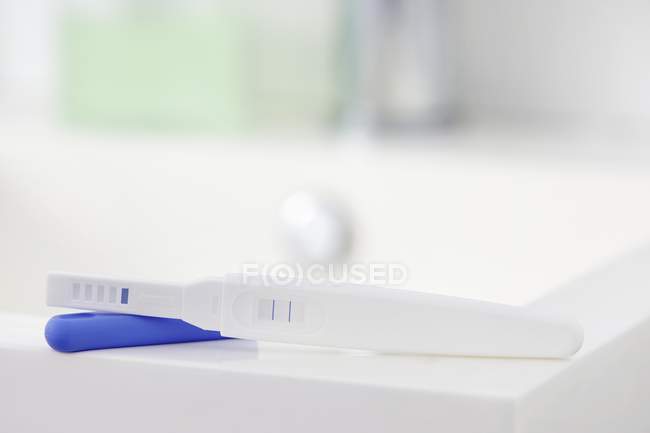Test di gravidanza che mostra risultati positivi sul tavolo . — Foto stock