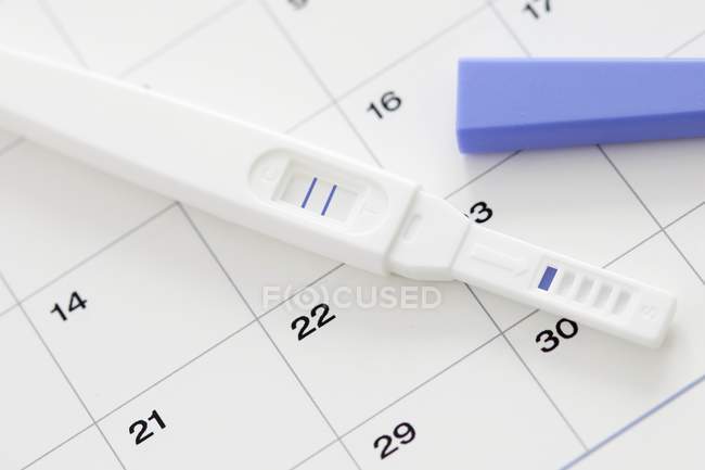 Test de grossesse montrant un résultat positif et calendrier
. — Photo de stock