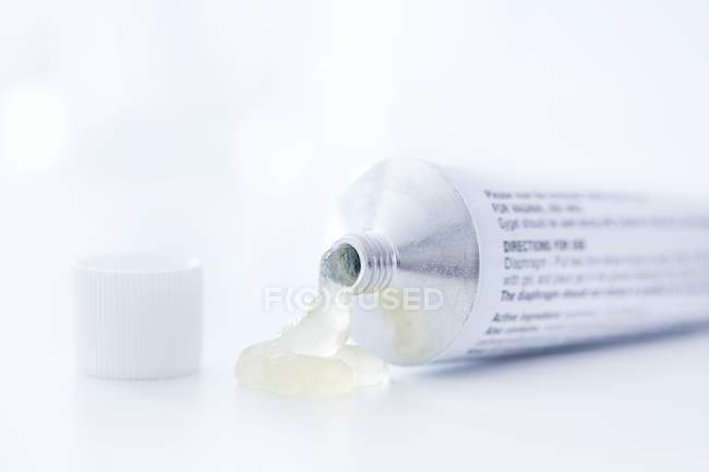 Gel contraccettivo versando su sfondo bianco . — Foto stock