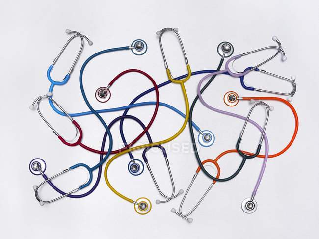 Estetoscopios multicolores clínicos sobre fondo blanco . - foto de stock