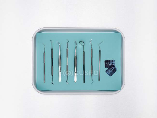 Zahnarztgeräte in Tablett vor weißem Hintergrund. — Stockfoto