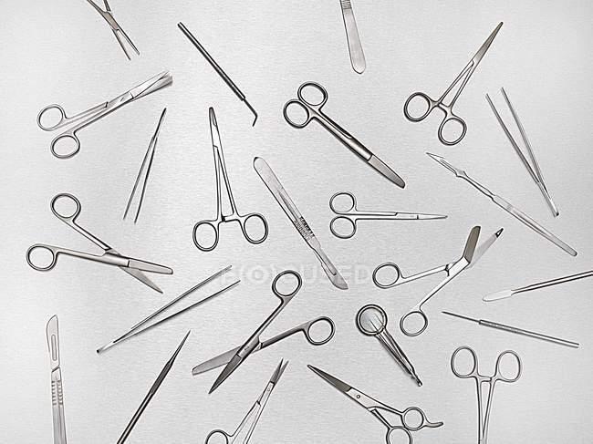 Forbici chirurgiche e strumenti su sfondo grigio . — Foto stock