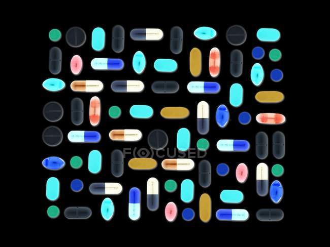 Layout piatto di pillole assortite e capsule sullo sfondo nero . — Foto stock