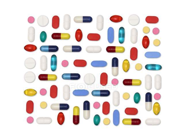 Flat lay of assorted pills and capsules against white background. — Stock Photo