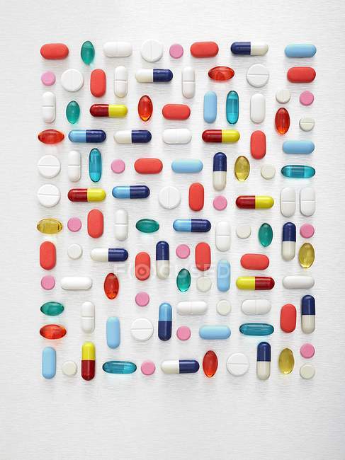 Pose plate de pilules et capsules assorties sur fond blanc . — Photo de stock