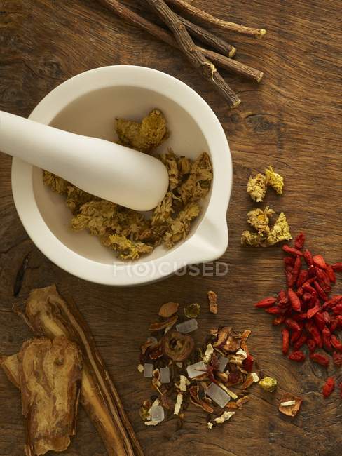 Herbs in mortar and pestle alternative medicine on wooden background. — Stock Photo