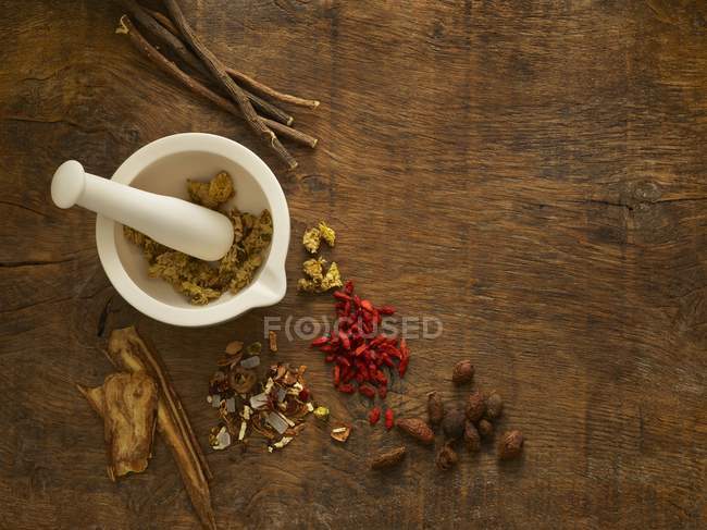 Herbs in mortar and pestle alternative medicine on wooden background. — Stock Photo