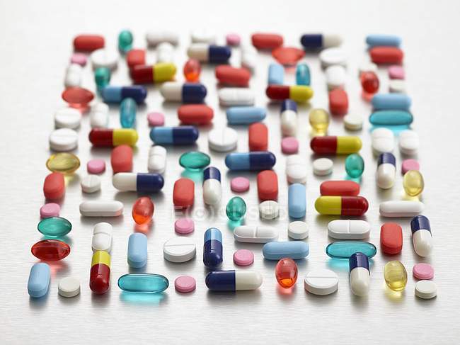 Pillole colorate e capsule disposizione su sfondo bianco
. — Foto stock
