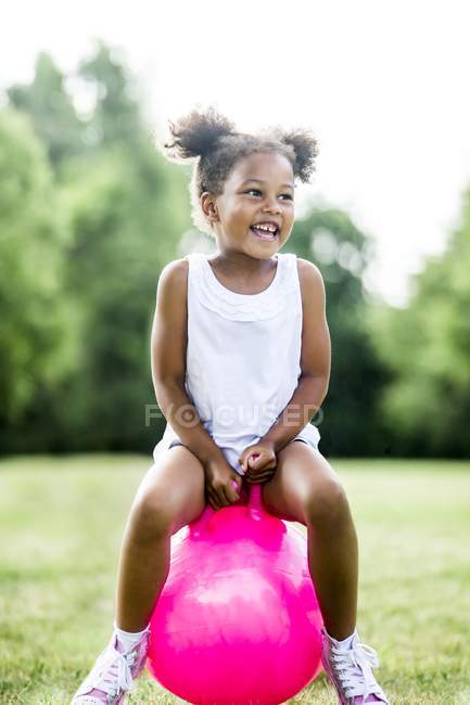 Preschooler girl bouncing on inflatable hopper in park and laughing. — Stock Photo