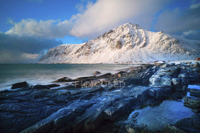 Playa de Rocky Kvalvika en la isla de Lofoten cubierta de nieve, Noruega . - foto de stock