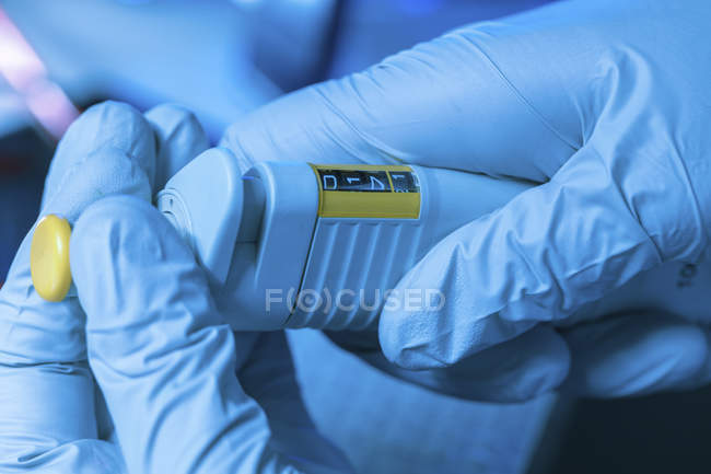Close-up of scientist hands adjusting micropipette. — Stock Photo
