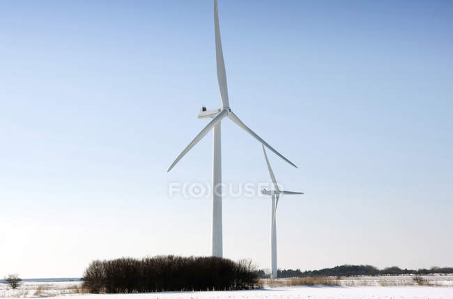Windkraftanlagen in verschneiter Winterlandschaft unter blauem Himmel in esbjerg, Dänemark. — Stockfoto