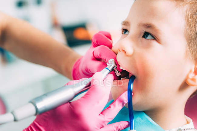Hands of female orthodontist working with little boy. — Stock Photo