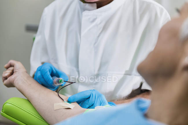 Médecin masculin tirant du sang de patiente pour le traitement cosmétique PRP . — Photo de stock