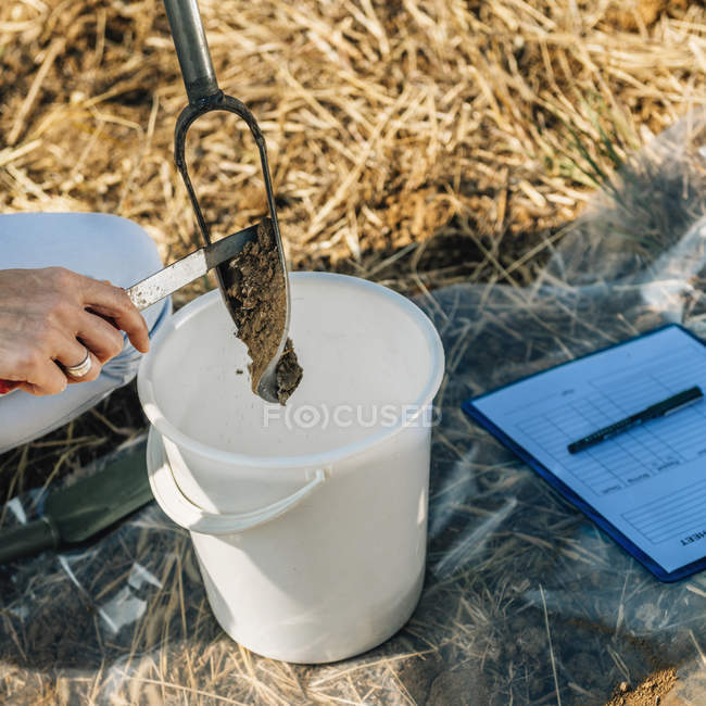 Agrónoma femenina tomando muestras con sonda de suelo . - foto de stock
