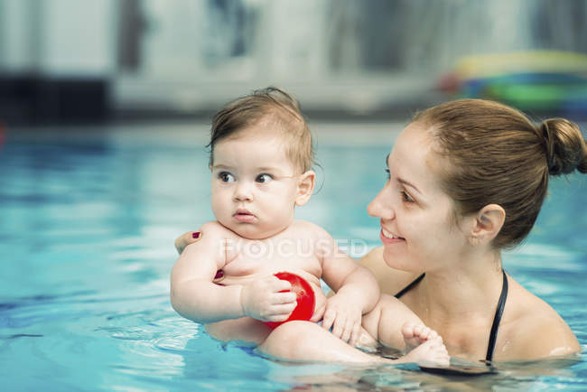Bambino e madre in piscina d'acqua . — Foto stock