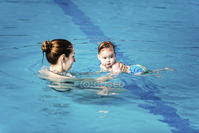 Дитячий хлопчик з матір'ю у басейні води . — стокове фото