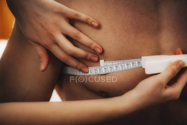 Médico que mide la circunferencia del pecho con cinta métrica en atleta masculino . - foto de stock