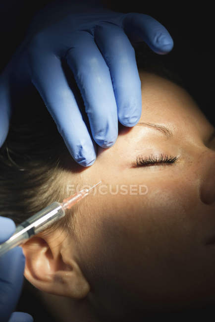 Close-up of woman receiving botox injection in face in clinic. — Stock Photo