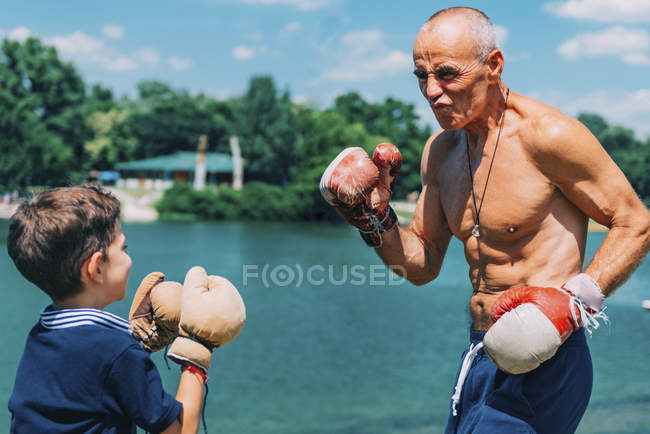 Дідусь і онук боксу біля озера на відкритому повітрі . — стокове фото