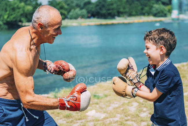 Дедушка и внук занимаются боксом на открытом воздухе . — стоковое фото