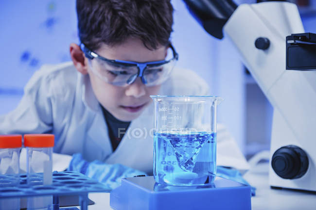 Schoolboy doing science experiment in school chemistry laboratory. — Stock Photo