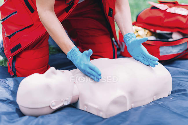 Mains de formation paramédicale féminine en RCR à l'extérieur . — Photo de stock