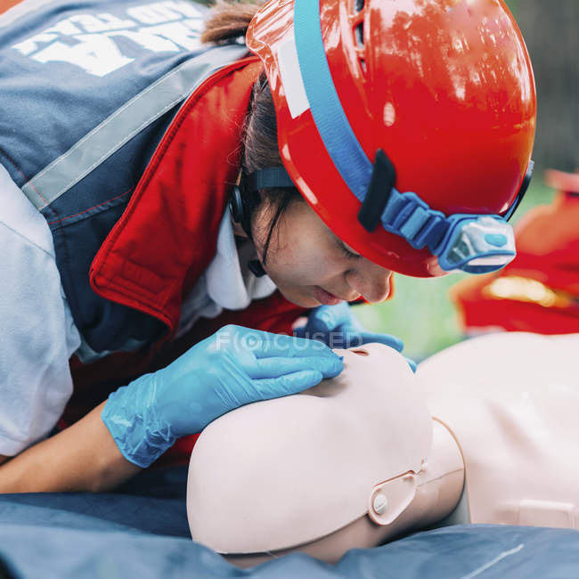 Female paramedic practicing mouth-to-mouth while CPR training outdoors. — Stock Photo