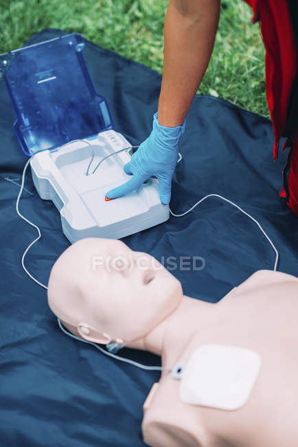 Treinamento paramédico desfibrilador feminino com manequim ao ar livre . — Fotografia de Stock