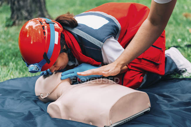 Instructor helping female paramedic with CPR training outdoors. — Stock Photo