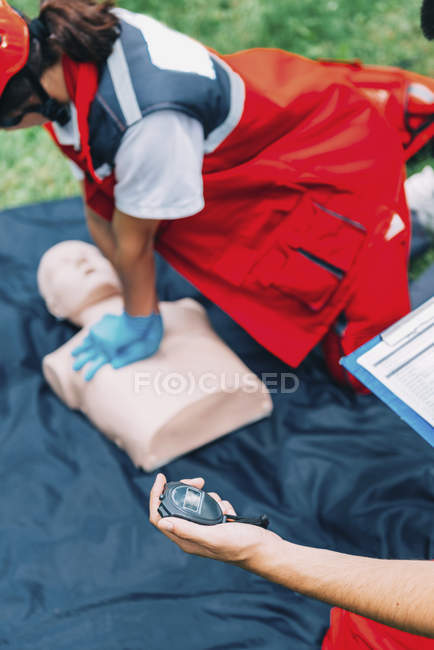 Female paramedic CPR training on dummy outdoors. — Stock Photo
