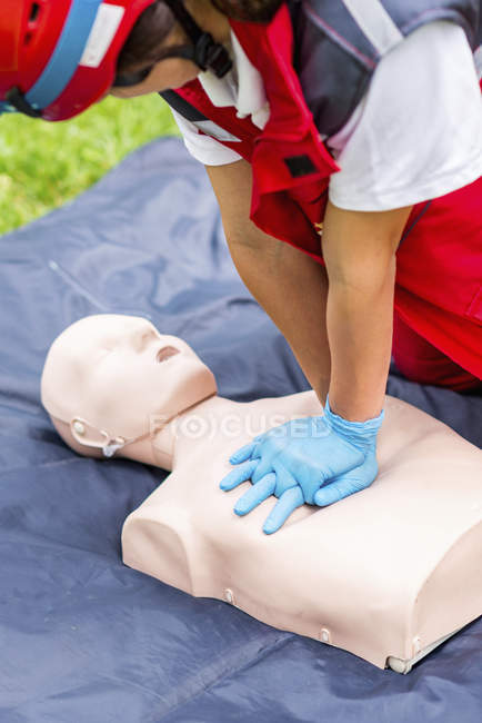Female paramedic CPR training with dummy outdoors. — Stock Photo