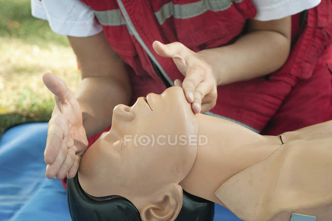 Женщина-парамедик практикует кардиолегочную реанимацию на манекене
. — стоковое фото