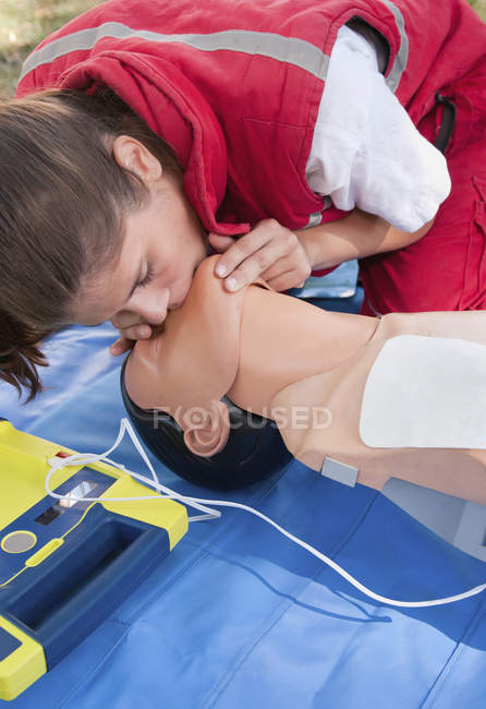 Женщина-парамедик практикует кардиолегочную реанимацию на манекене . — стоковое фото