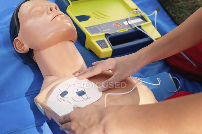 Жіночий парамедик з використанням дефібрилятора під час тренування на манері CPR . — стокове фото