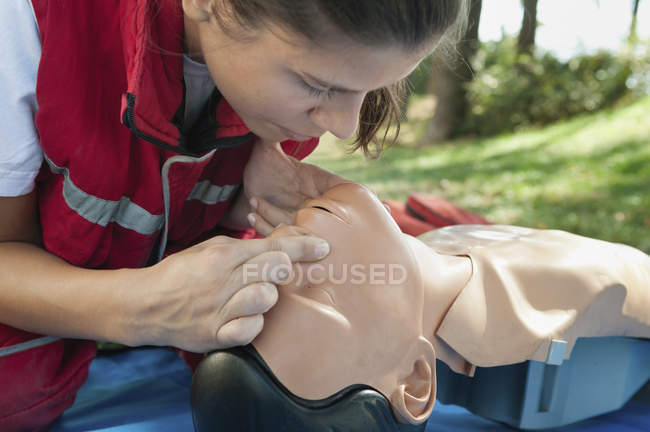 Female paramedic CPR practice on CPR dummy, mouth to mouth. — Stock Photo
