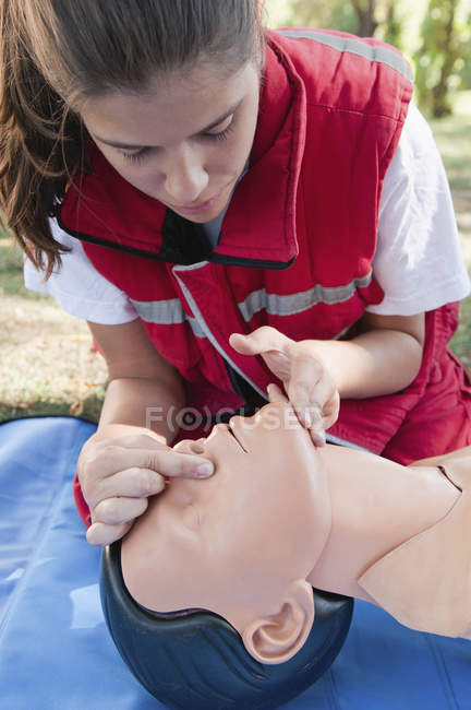 Entrenamiento de RCP paramédico femenino en maniquí al aire libre . - foto de stock